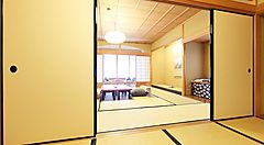 Stanza tradizionale con tatami e porte scorrevoli al Gion Hatanaka Ryokan a Kyoto.