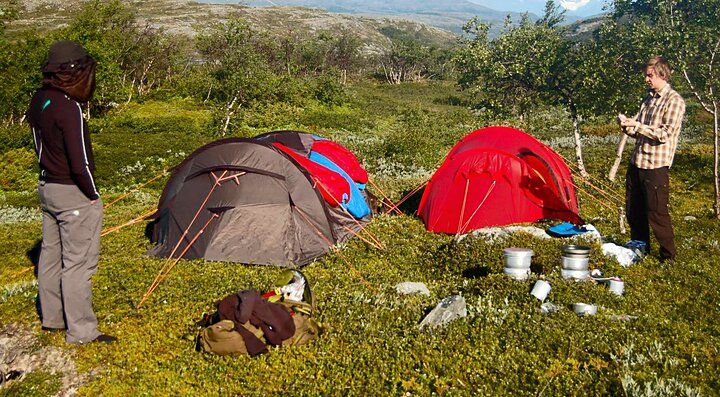 Due campeggiatori montano la tenda in un montagna.