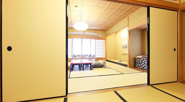 Stanza tradizionale con tatami e porte scorrevoli al Gion Hatanaka Ryokan a Kyoto.