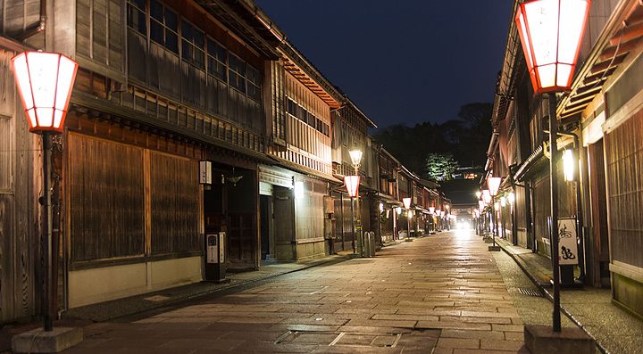 Strada tradizionale illuminata a Kanazawa di sera.