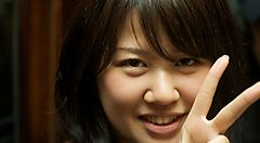 Persona sorridente fa il segno di pace con le dita.
