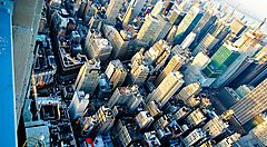 Vista aerea di una città con numerosi grattacieli e strade affollate.
