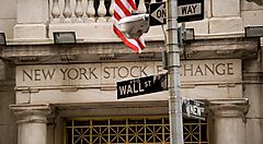Dettaglio della scritta all'ingresso della Borsa di New York, ed indicazioni stradali che indicano Wall Street.