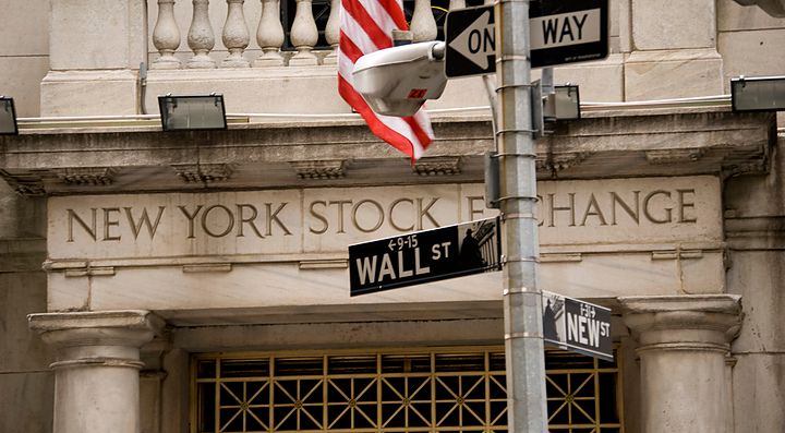 Dettaglio della scritta all'ingresso della Borsa di New York, ed indicazioni stradali che indicano Wall Street.