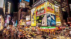 Times Square di sera, con molto traffico e tanta gente.