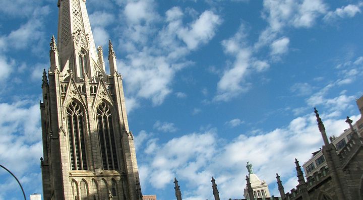 Chiesa gotica con cielo blu e nuvole sullo sfondo.