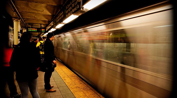 Un treno in movimento in una stazione della metropolitana affollata.