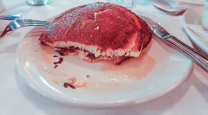 Pancake su un piatto bianco con una forchetta e un coltello accanto.