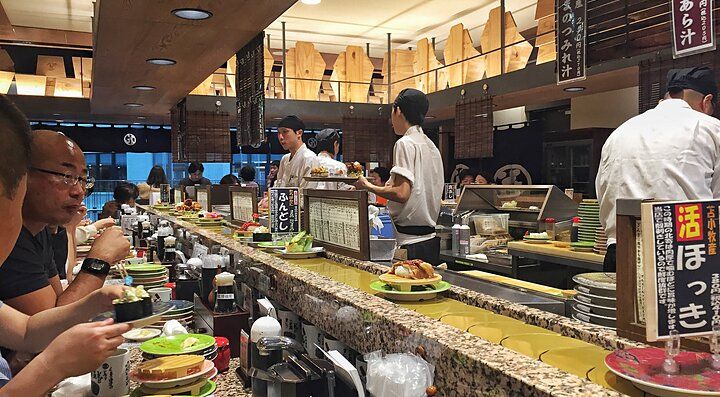 Ristorante di sushi Nemuro Hanamaru con clienti al bancone.