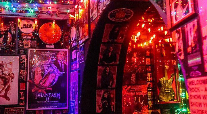Interno del Duff's Bar a Brooklyn con decorazioni luminose e poster rock.