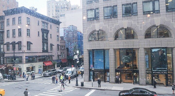 Edificio di Barneys a New York con persone sulla strada trafficata.
