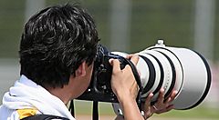 Un fotografo mentre usa un teleobiettivo.