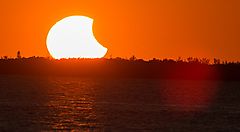 Eclissi parziale di Sole, con il Sole all'orizzonte.