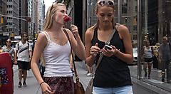 Due giovani donne camminano per strada in una città con grattacieli.