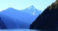 Montagne innevate riflesse su un lago al tramonto.