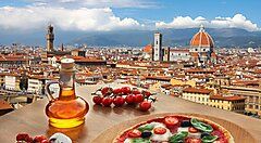 Veduta di Firenze con pizza e olio d'oliva in primo piano.