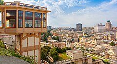 Vista panoramica della città di Genova con edifici e un ascensore pubblico.