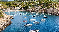 Barche ormeggiate in una baia circondata da colline a Ibiza.