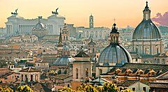 Veduta panoramica delle cupole e monumenti di Roma al tramonto.