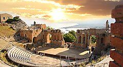 Teatro antico con vista sul mare a Taormina al tramonto.