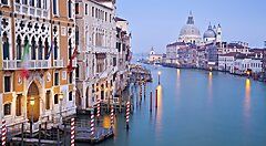 Suggestivo canale veneziano al tramonto con edifici storici.