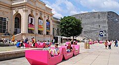 Piazza con sedute rosa e edifici moderni nel centro di Vienna.