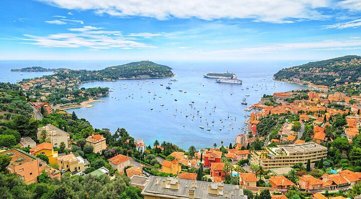 Vista panoramica della costa di Nizza con la baia e numerose imbarcazioni.