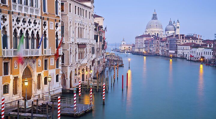 Suggestivo canale veneziano al tramonto con edifici storici.