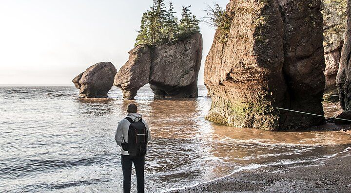 Persona osserva formazioni rocciose uniche sulla costa del Canada.