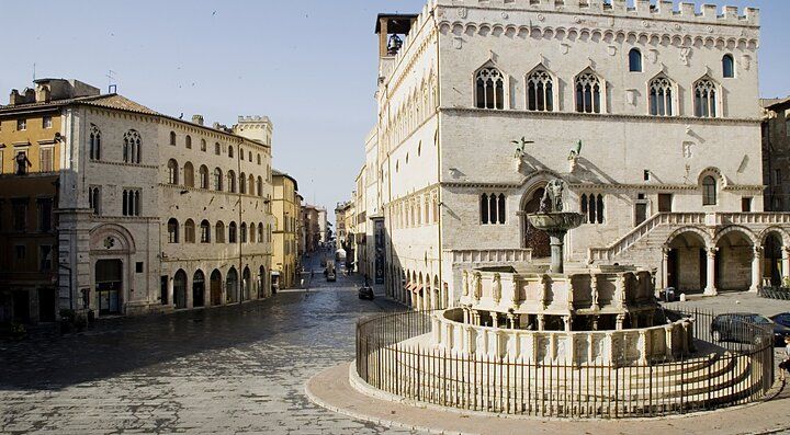 Fontana e architettura storica in una piazza di Perugia.