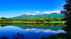 Paesaggio dei cinque laghi di Shiretoko con montagne riflesse nell'acqua.