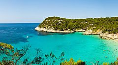 Baia con acqua turchese e vegetazione a Minorca.