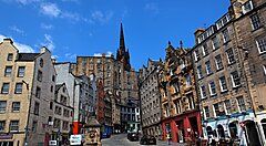 Una strada storica di Edimburgo con edifici classici e un cielo blu.