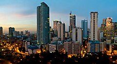 Skyline di Manila al tramonto con grattacieli illuminati.