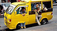 Minibus giallo con passeggeri a Phuket, Thailandia.
