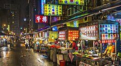 Mercato notturno a Taiwan con bancarelle illuminate di cibo.