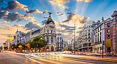 Gran Via a Madrid al tramonto con edifici storici.