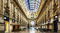 Galleria Vittorio Emanuele II a Milano con passanti e negozi.