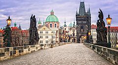 Ponte Carlo a Praga con statue e luci lungo il percorso.