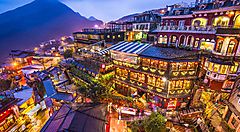 Veduta serale di edifici illuminati tra le montagne a Taiwan.