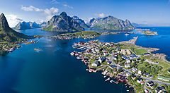 Veduta aerea di un villaggio costiero con montagne e fiordo in Norvegia.
