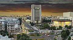 Vista panoramica del centro di Bucarest al tramonto con edifici moderni.