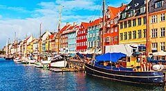 Case colorate lungo il canale Nyhavn a Copenaghen con barche in primo piano.
