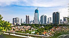 Vista panoramica dello skyline di Giacarta con grattacieli e vegetazione.