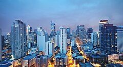 Skyline serale di Manila illuminata con edifici moderni.