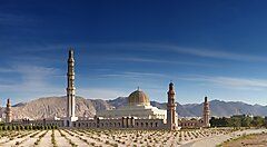 La Grande Moschea del Sultano Qaboos a Muscat con montagne sullo sfondo.