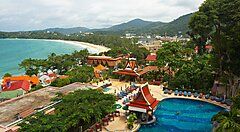 Vista panoramica su un resort a Phuket con piscina e spiaggia vicina.
