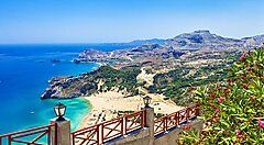 Vista panoramica di una costa a Rodi con mare cristallino e montagne.
