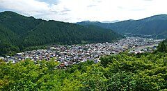 Vista panoramica di Gujo-Hachiman circondata da colline verdi.