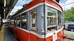 Il treno rosso della Ferrovia Hakone Tozan fermo in stazione.
